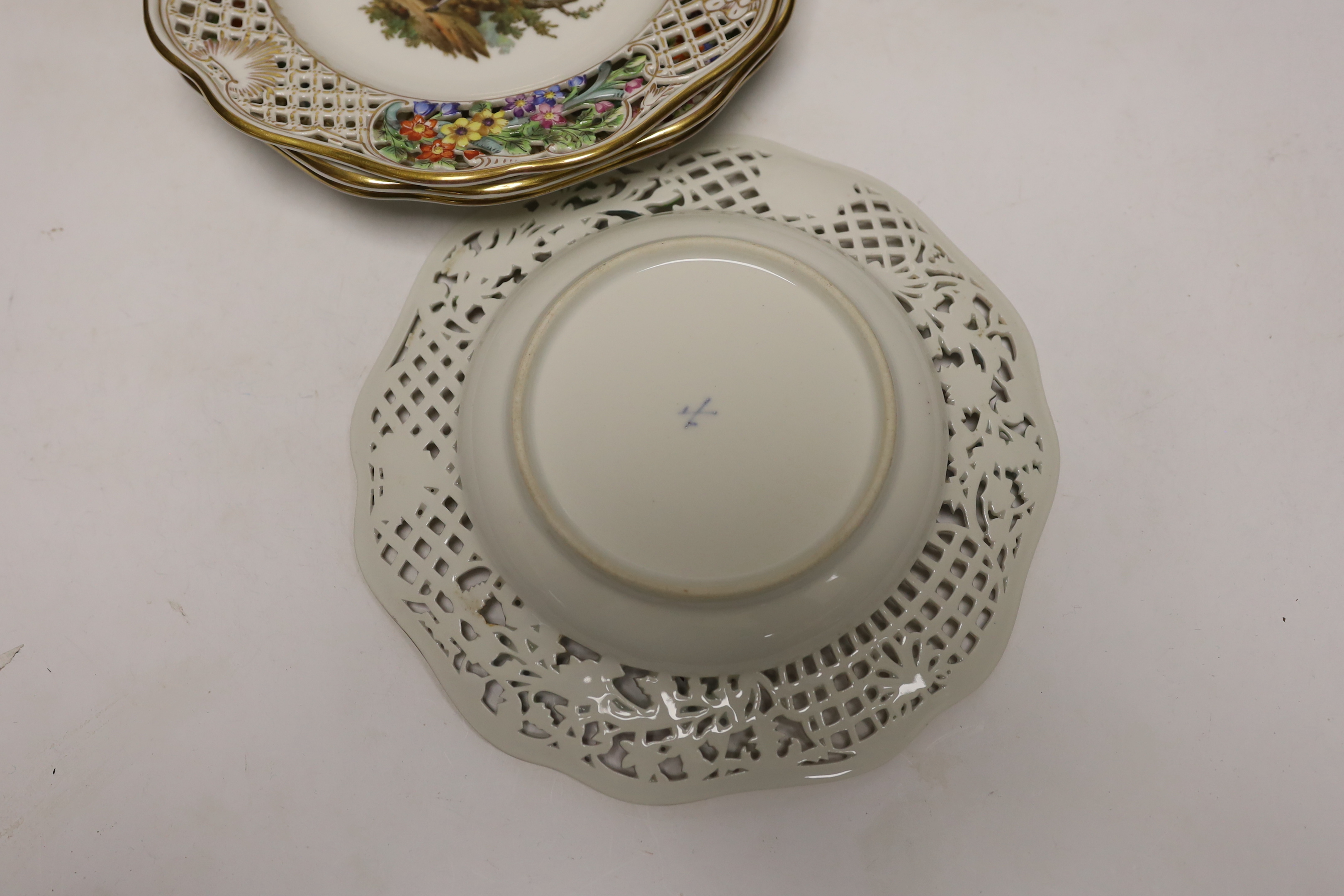 A Dresden Meissen style part dessert set, painted with courting couples in the landscape, consisting of a comport two dishes and four plates, comport 15.5cm high